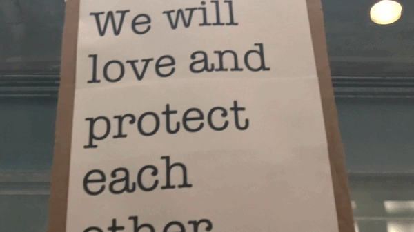 We will love and protect each other sign at Bradley Airport protest against Trump Administration's Muslim ban