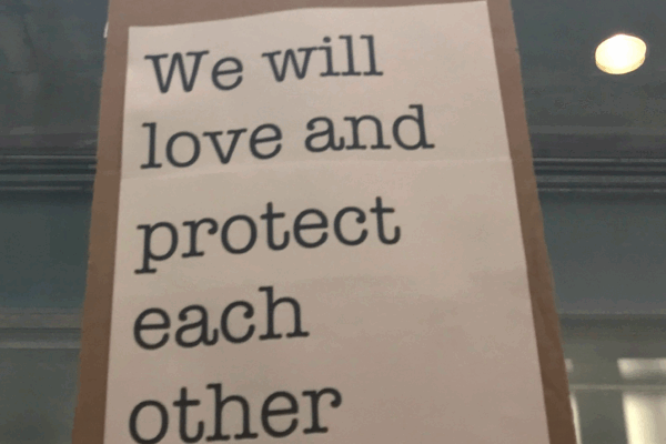 We will love and protect each other sign at Bradley Airport protest against Trump Administration's Muslim ban