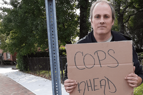 ACLU of Connecticut client protester Michael Friend holds "cops ahead" sign in Stamford