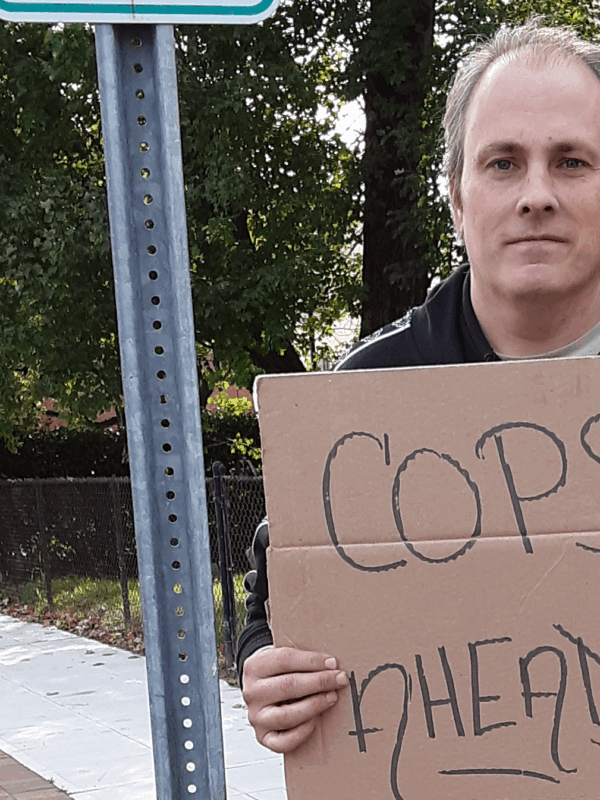 ACLU of Connecticut client protester Michael Friend holds "cops ahead" sign in Stamford