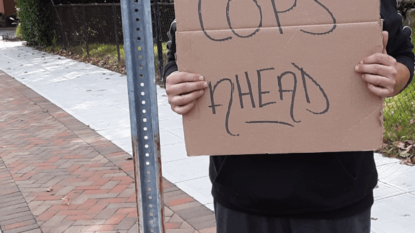 ACLU of Connecticut lawsuit plaintiff protester Michael Friend holds "cops ahead" sign in Stamford
