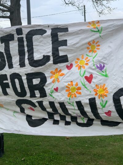 Protesters in Wethersfield hold a "justice for chulo" banner demanding justice for Anthony "Chulo" Vega, who was shot and killed by Wethersfield police