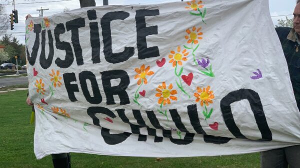 Protesters in Wethersfield hold a "justice for chulo" banner demanding justice for Anthony "Chulo" Vega, who was shot and killed by Wethersfield police