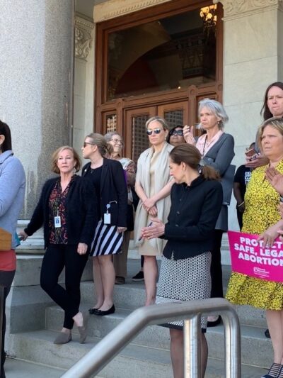 ACLU-CT speaks at abortion access rally in Hartford. Signs say "abortion is healthcare, abortion is a right" and "protect safe, legal abortion."