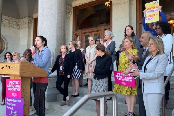 ACLU-CT speaks at abortion access rally in Hartford. Signs say "abortion is healthcare, abortion is a right" and "protect safe, legal abortion."