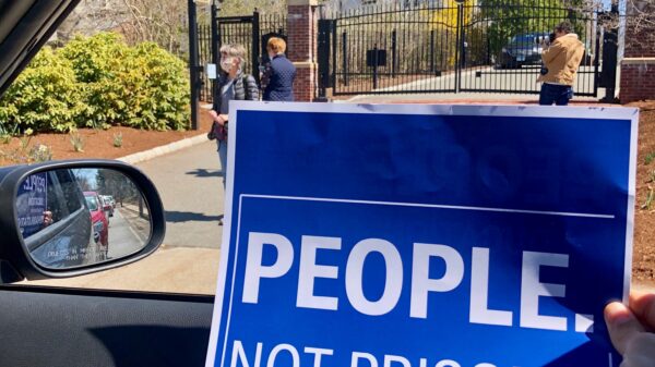 blue aclu of connecticut people not prisons poster in front of Connecticut governor's mansion