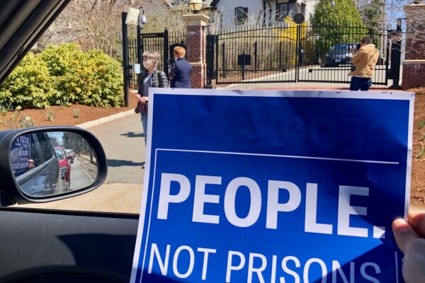 blue aclu of connecticut people not prisons poster in front of Connecticut governor's mansion