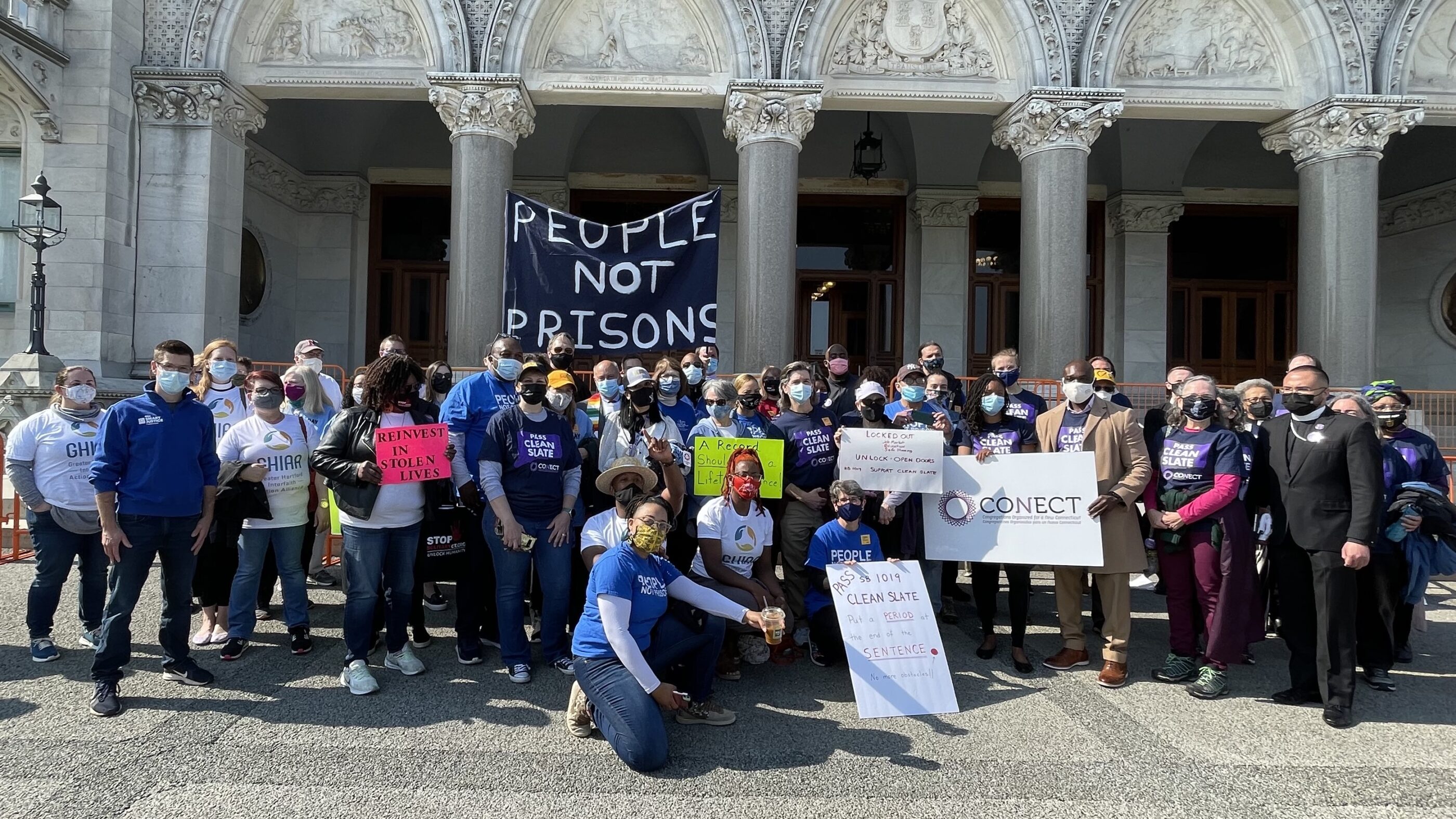 Group photo in front of the capitol after the Clean Slate press conference. A people not prisons sign can be seen.