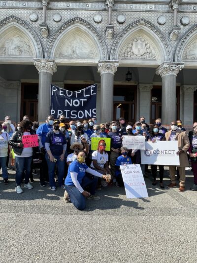 Group photo in front of the capitol after the Clean Slate press conference. A people not prisons sign can be seen.