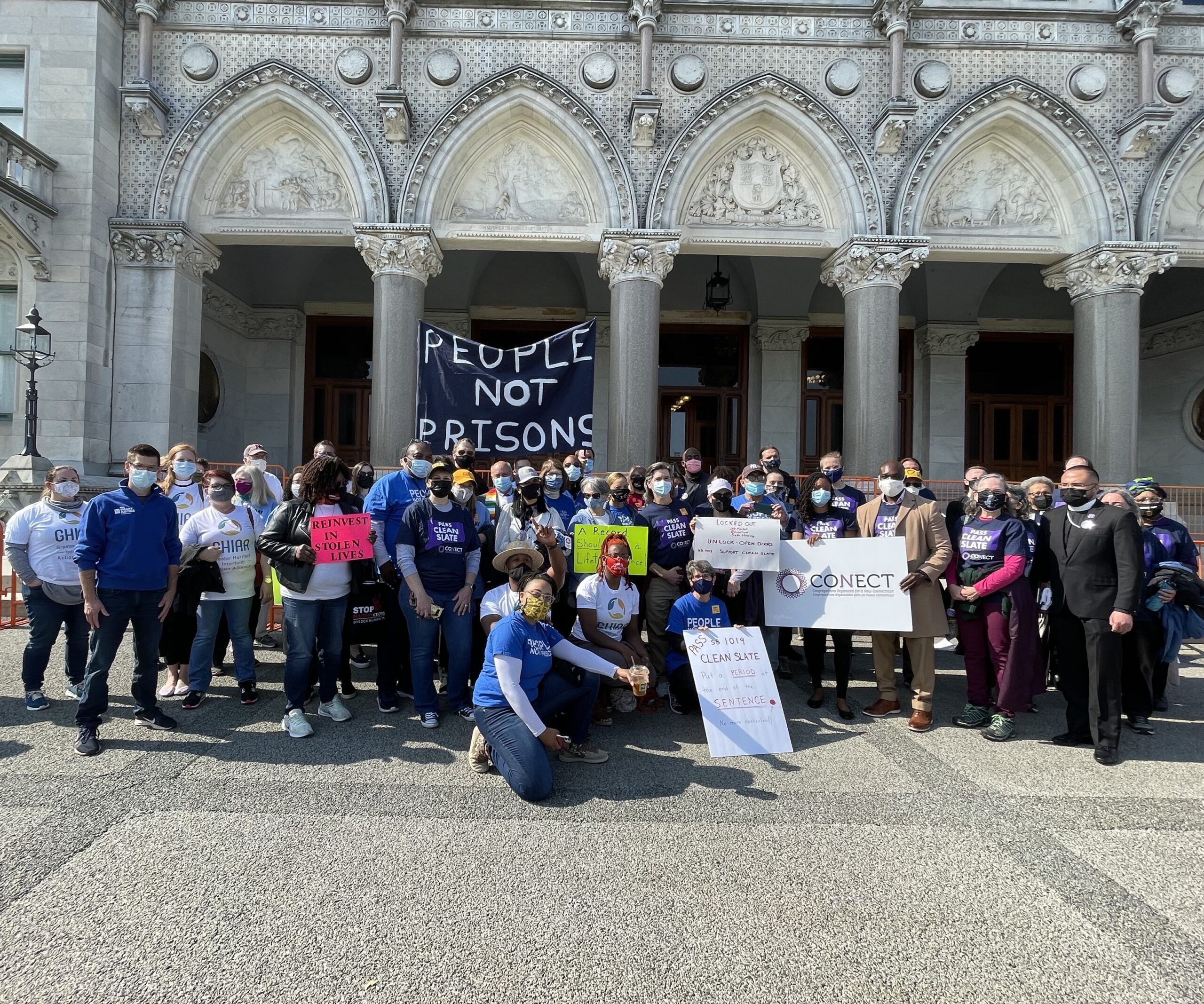 Group photo in front of the capitol after the Clean Slate press conference. A people not prisons sign can be seen.