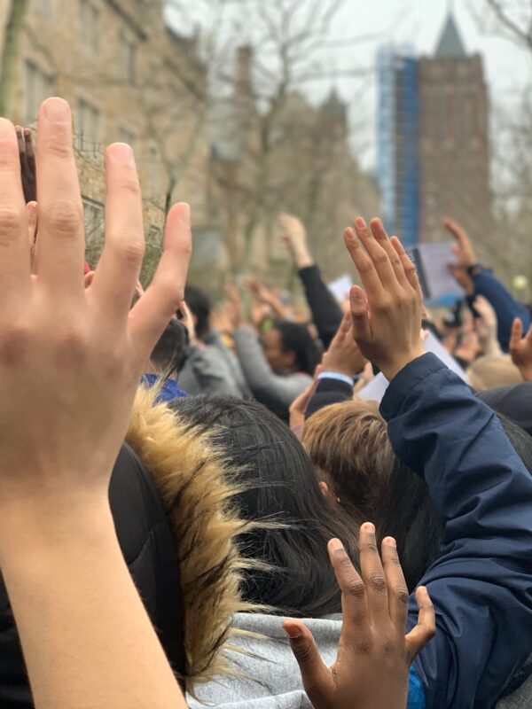 Photo of people with hands raised.