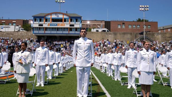 US Coast Guard cadets in white uniforms stand in neat rows at the commencement for the United States Coast Guard Academy in New London, Conn.