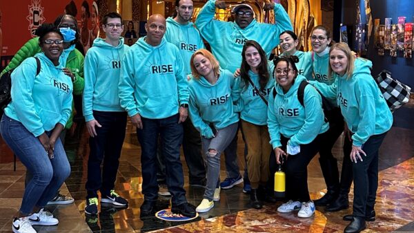 Group of individuals wearing green Rise PAC sweatshirts