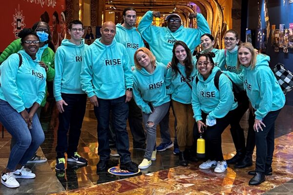Group of individuals wearing green Rise PAC sweatshirts