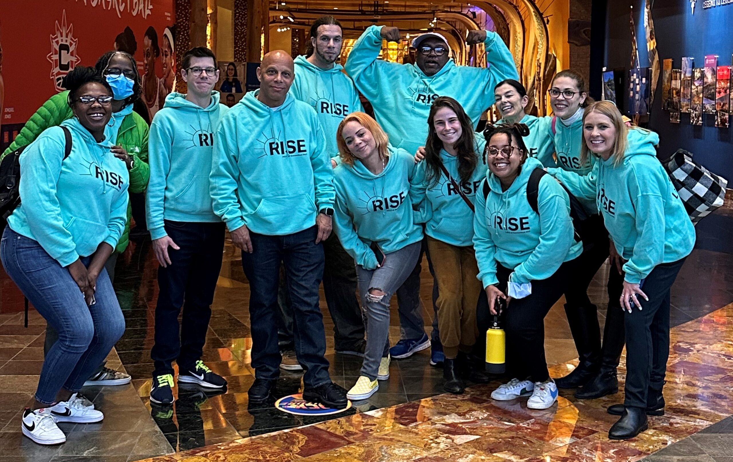 Group of individuals wearing green Rise PAC sweatshirts