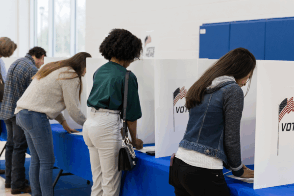 group of individuals casting their ballot at the polls