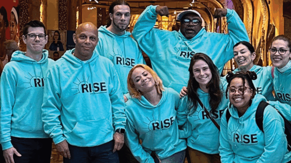 ACLU-CT rise PAC advocates stand, smiling at the camera. they are wearing light green ACLUCT Rise PAC hoodies