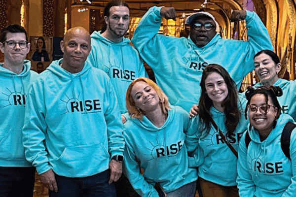 ACLU-CT rise PAC advocates stand, smiling at the camera. they are wearing light green ACLUCT Rise PAC hoodies
