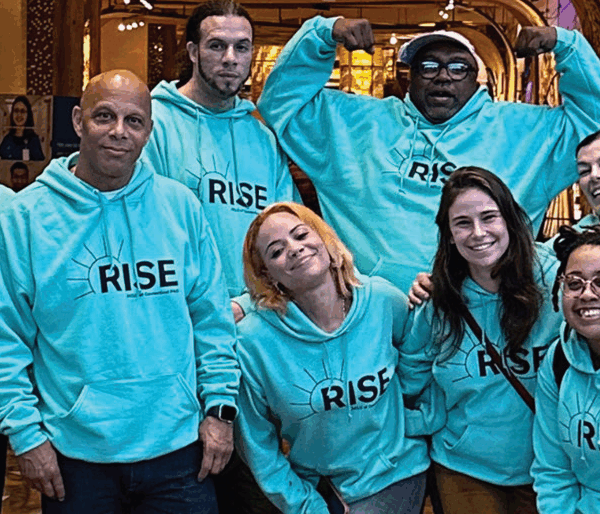 ACLU-CT rise PAC advocates stand, smiling at the camera. they are wearing light green ACLUCT Rise PAC hoodies
