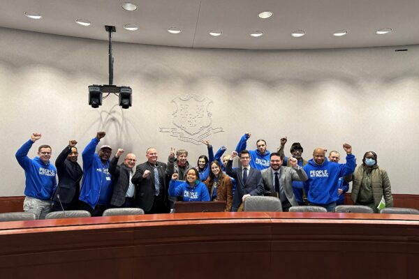 innocence project and acluct smart justice gather for press conference combatting police deception, all are standing or crouching, smiling, with fists raised