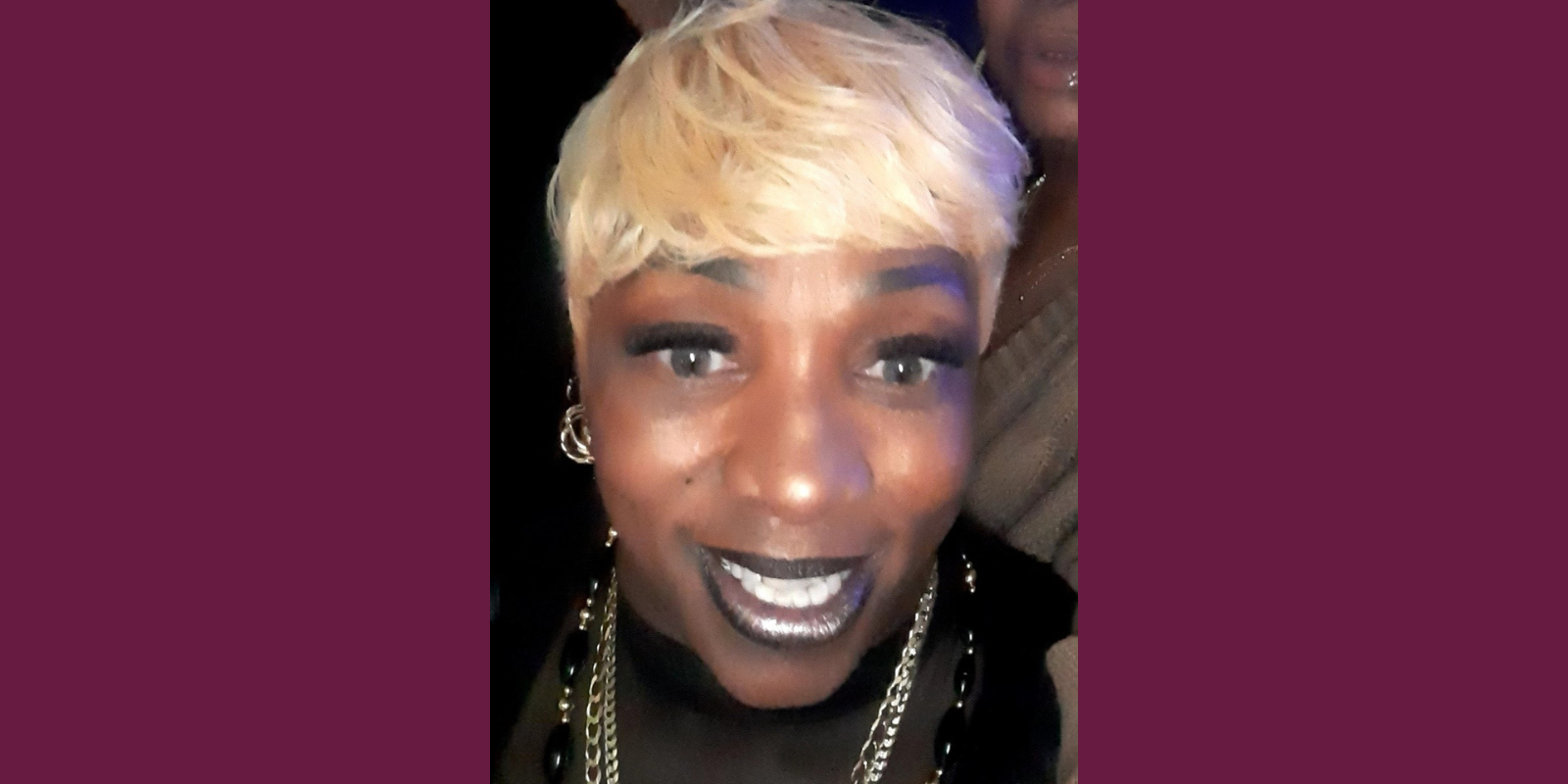 Teresa Beatty, a Black woman with short blond hair, looks at the camera, smiling.