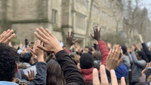 A crowd of hands are raised above people's heads.