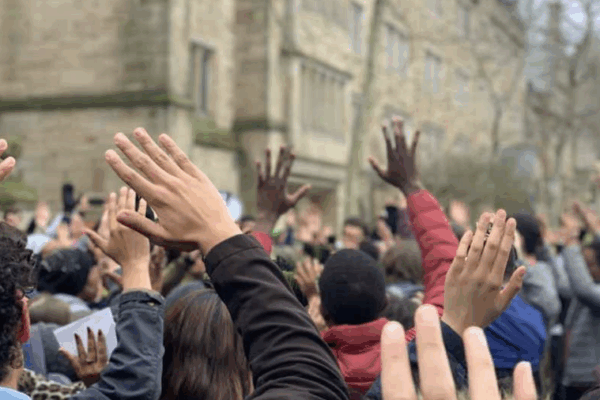 A crowd of hands are raised above people's heads.