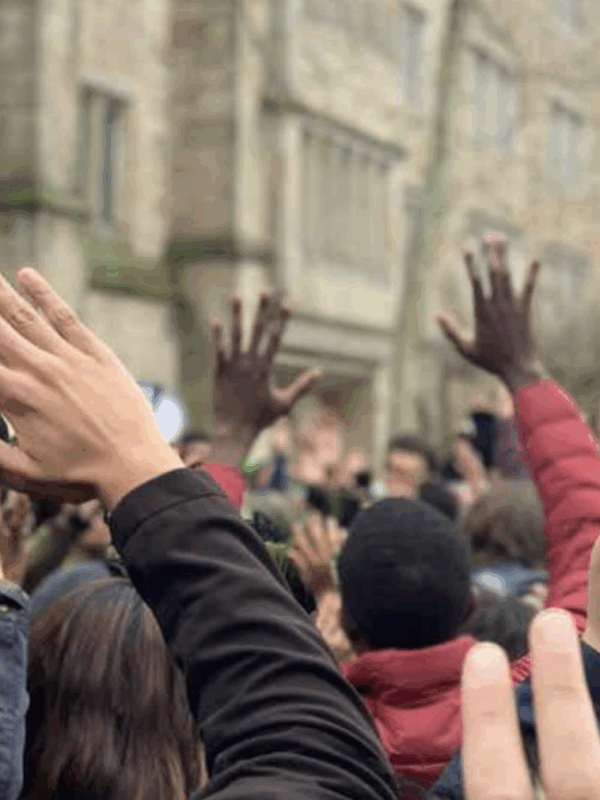 A crowd of hands are raised above people's heads.