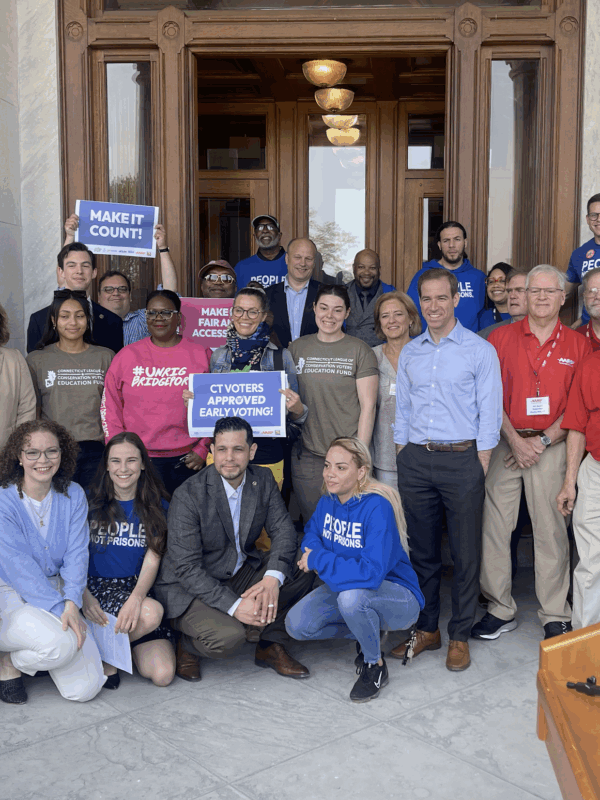 ACLU-CT staff and partners are posing in front of the camera with signs to promote the CTVRA.