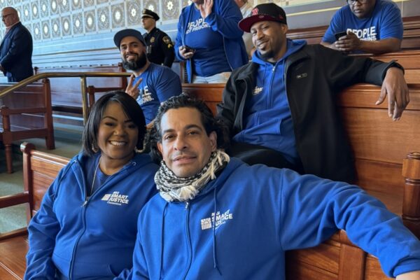 In the Senate room, five of our Smart Justice leaders are sitting together and smiling at the camera with their Smart Justice blue apparel.