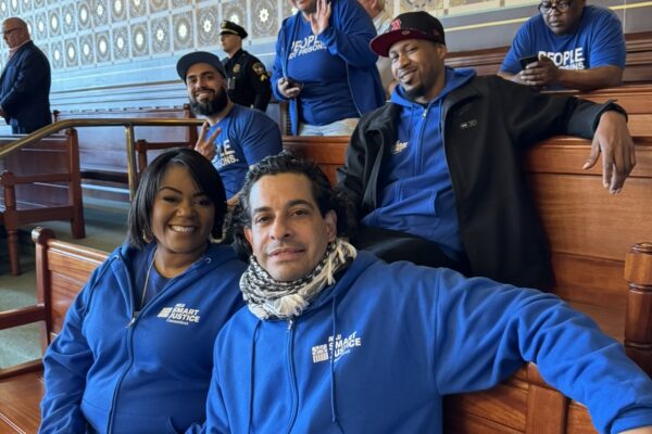 Six Smart Justice leaders sit in the senate room smiling at the camera.