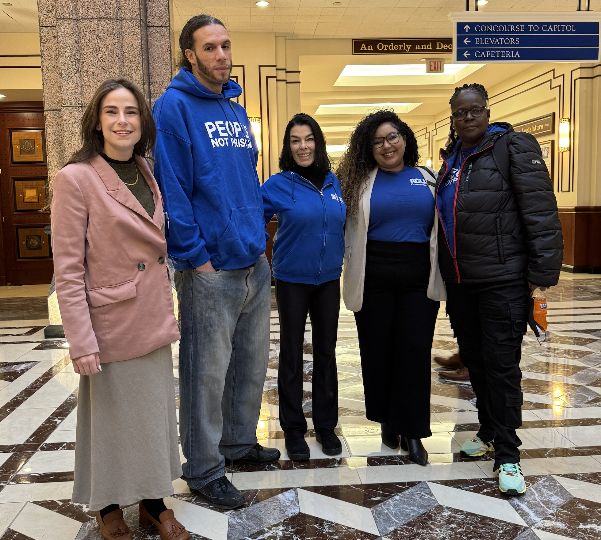 Jess, Will, L, Chelsea-Infinity, and Terri stand at the Capitol smiling at the camera.