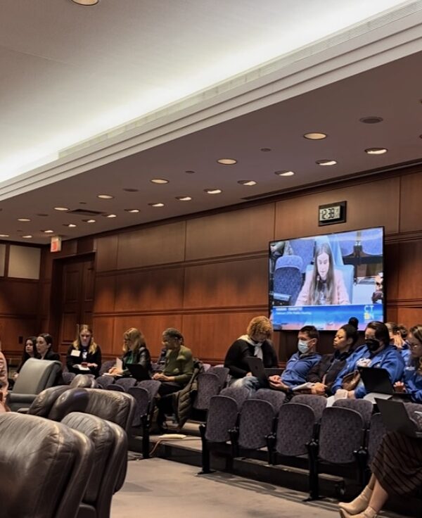 Jess, policy counsel, sits in front of the housing committee testifying in support of HB5242 with Smart Justice leaders behind her.