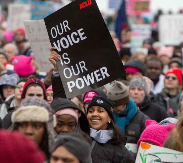 In a crowd of people at the Women's March, the focal point is on one black sign that reads in white, "Our Voice is Our Power."