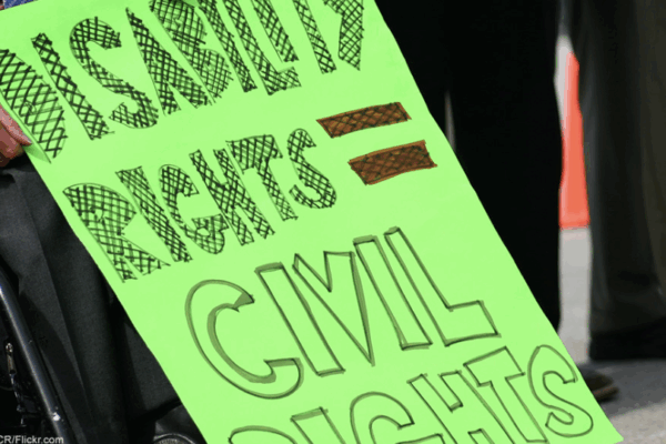The focus of this image is a neon green sign that reads "Disability rights = Civil rights."