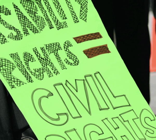 The focus of this image is a neon green sign that reads "Disability rights = Civil rights."