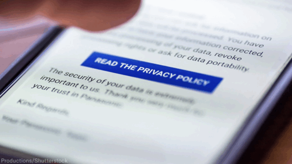 On a phone screen, there is a blur on everything except a blue button on the screen that says "READ THE PRIVACY POLICY."