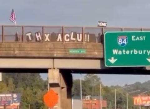 Above the infamous I-84, protestors are holding up signs that read "THX ACLU"