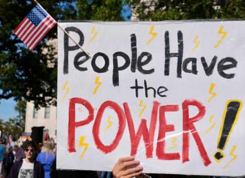 A white poster sign that reads the following in black: "People have the POWER" with little lightning bolts drawn randomly around the sign.