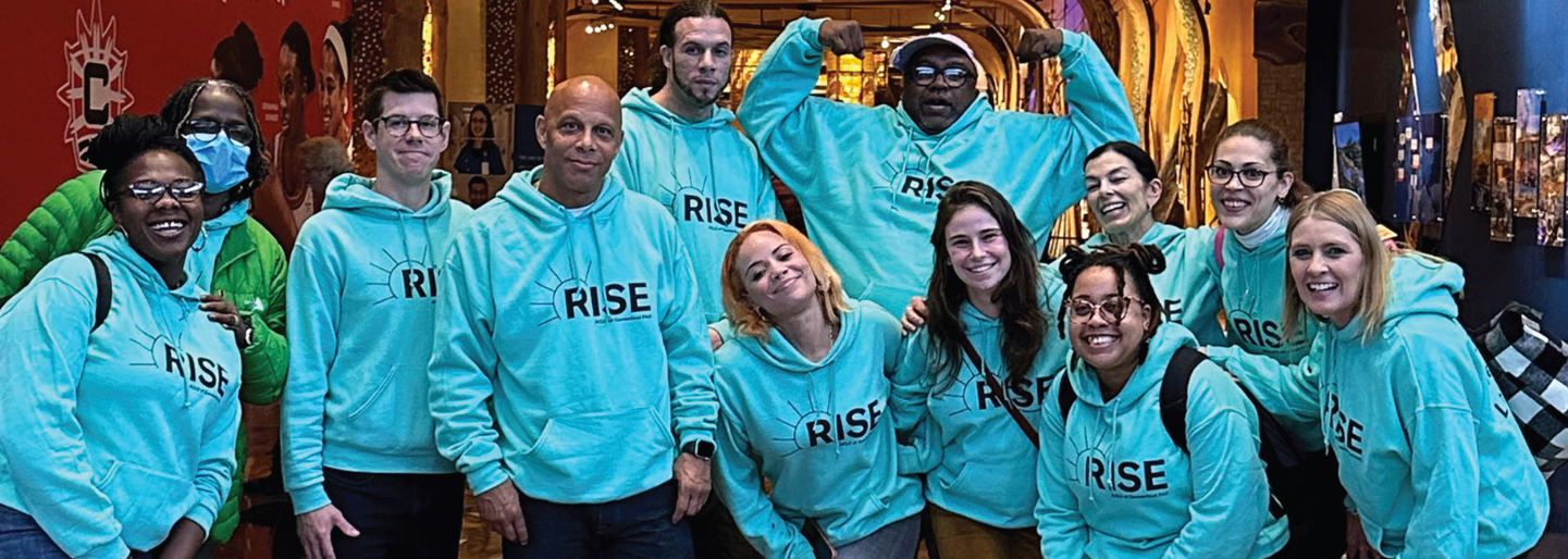 ACLU-CT rise PAC advocates stand, smiling at the camera. they are wearing light green ACLUCT Rise PAC hoodies