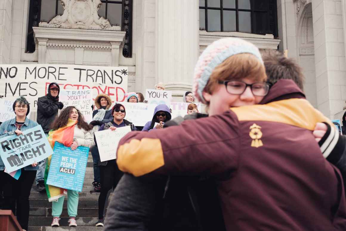ACLU supporters and LGBTQ advocates hug during rally for transgender youth in Hartford, Connecticut