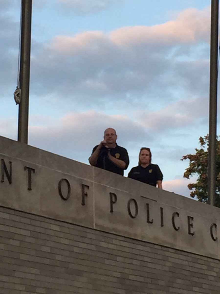 Bridgeport police officers record peaceful protesters from a rooftop