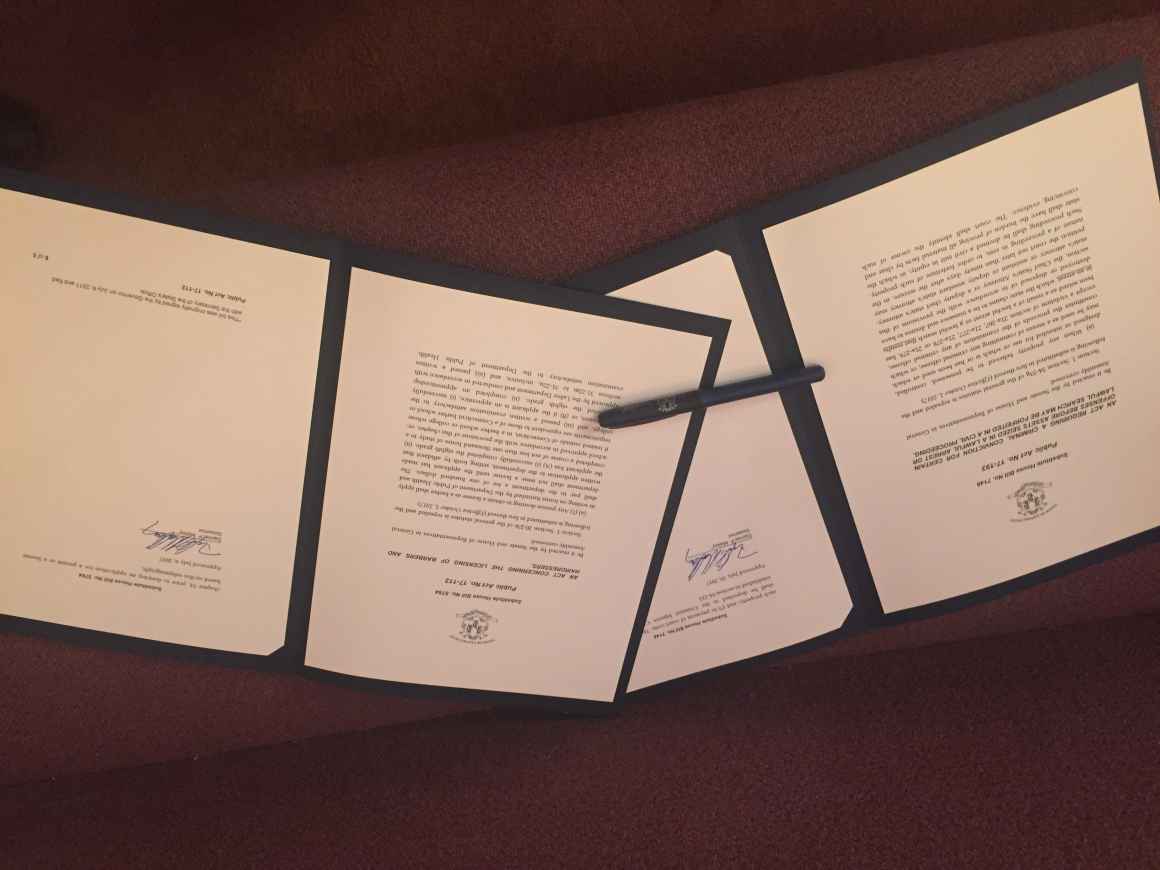 Ceremonial copies of Connecticut's 2017 civil asset forfeiture reform and fair chance licensure for babers and hairdressers laws