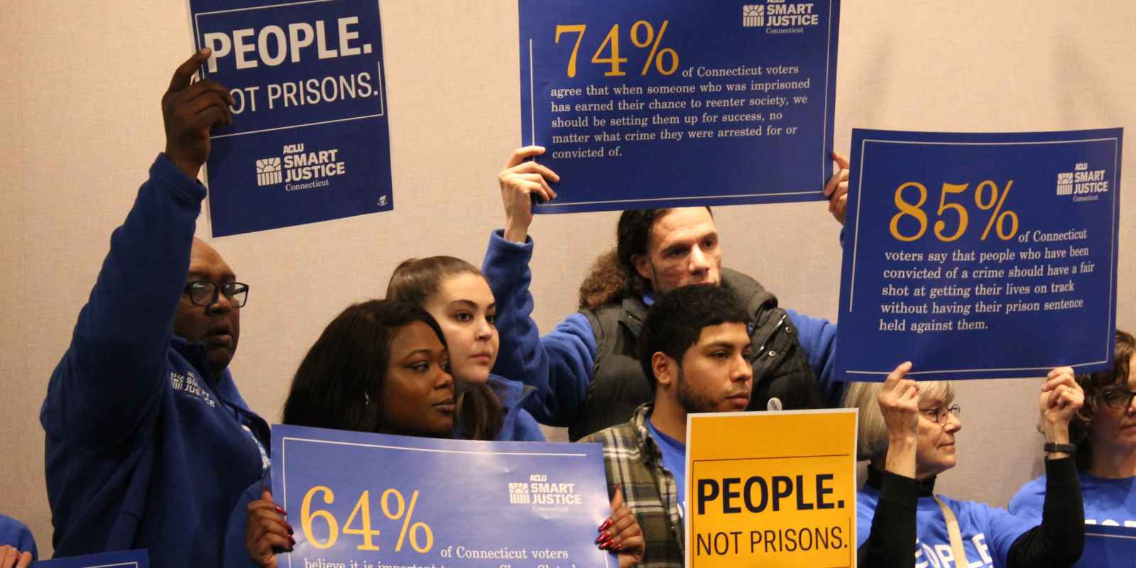 ACLU-CT Smart Justice leaders stand with "people not prisons" posters at a Connecticut Clean Slate pres conference