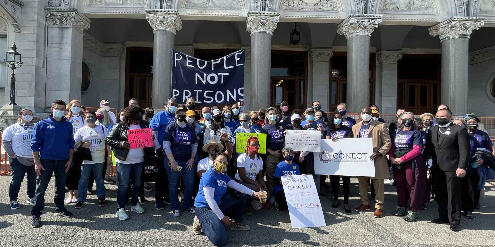 Group photo in front of the capitol after the Clean Slate press conference. A people not prisons sign can be seen.