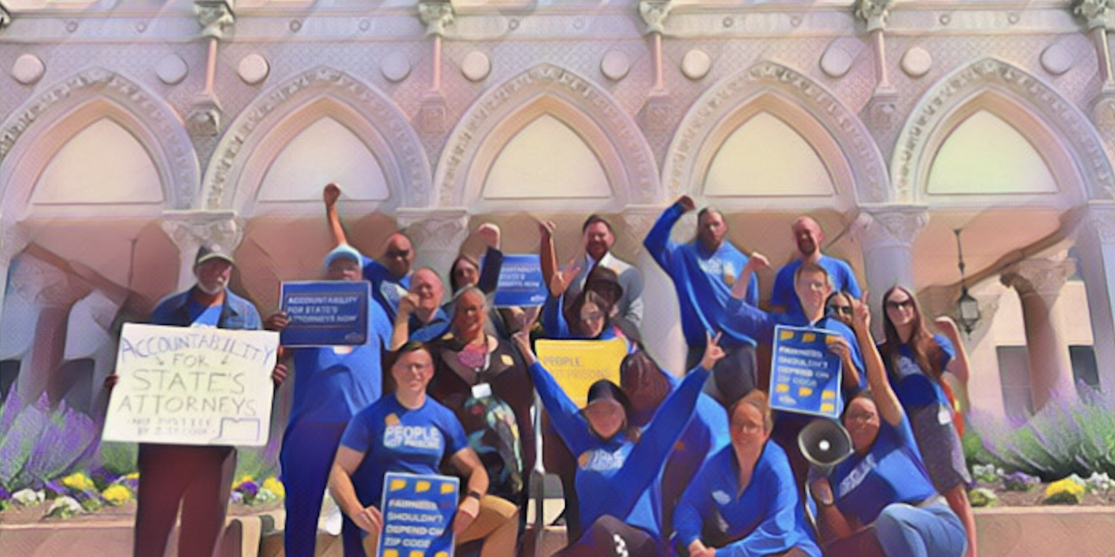 Smart Justice leaders are smiling at the camera in front of the Capitol building with signs that promote prosecutorial accountability.