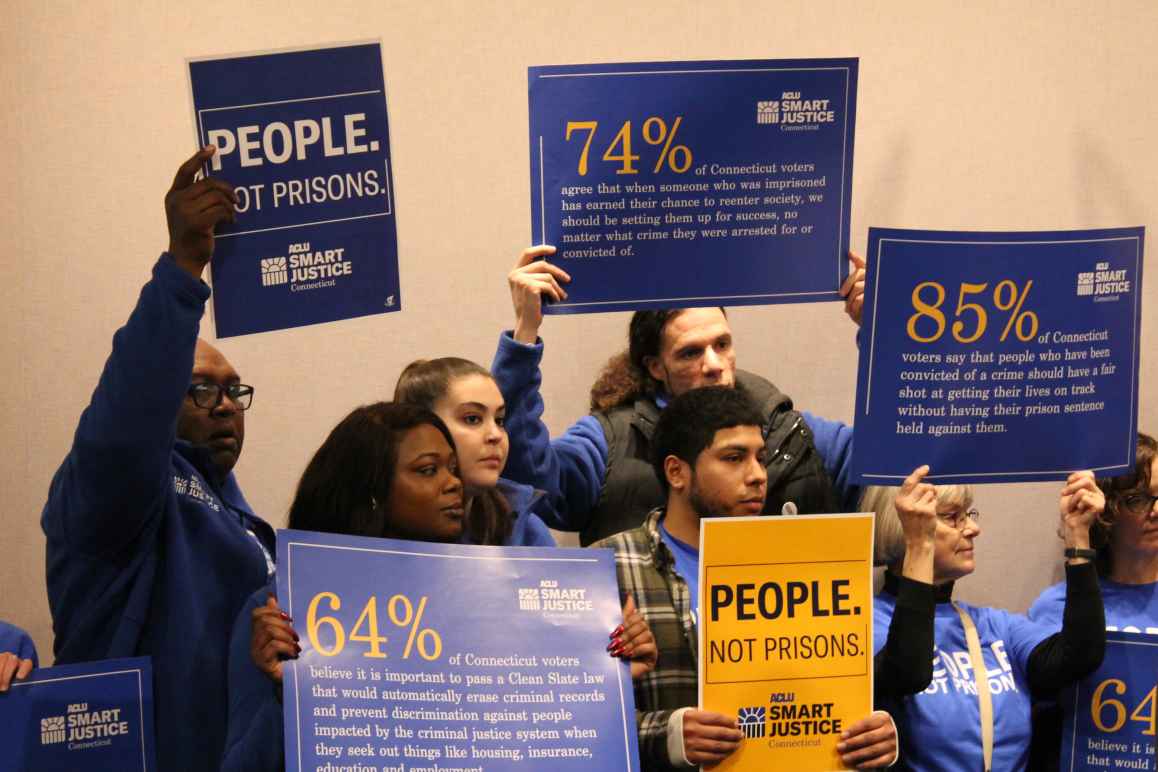 ACLU-CT Smart Justice leaders stand with "people not prisons" posters at a Connecticut Clean Slate pres conference