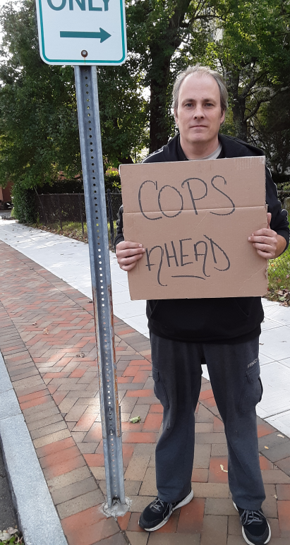 ACLU of Connecticut lawsuit plaintiff protester Michael Friend holds "cops ahead" sign in Stamford