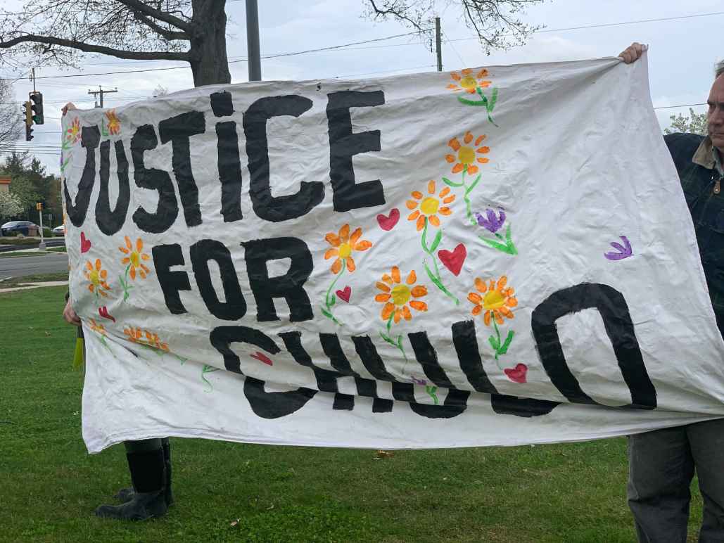 Protesters in Wethersfield hold a "justice for chulo" banner demanding justice for Anthony "Chulo" Vega, who was shot and killed by Wethersfield police