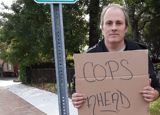 ACLU of Connecticut client protester Michael Friend holds "cops ahead" sign in Stamford